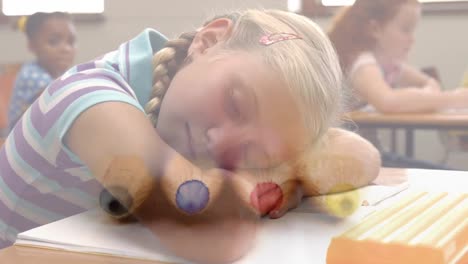 Animation-of-crayons-over-caucasian-girl-sleeping-on-desk-at-school