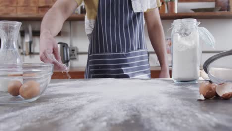 midsection of caucasian man preparing bread dough in kitchen, copy space, slow motion