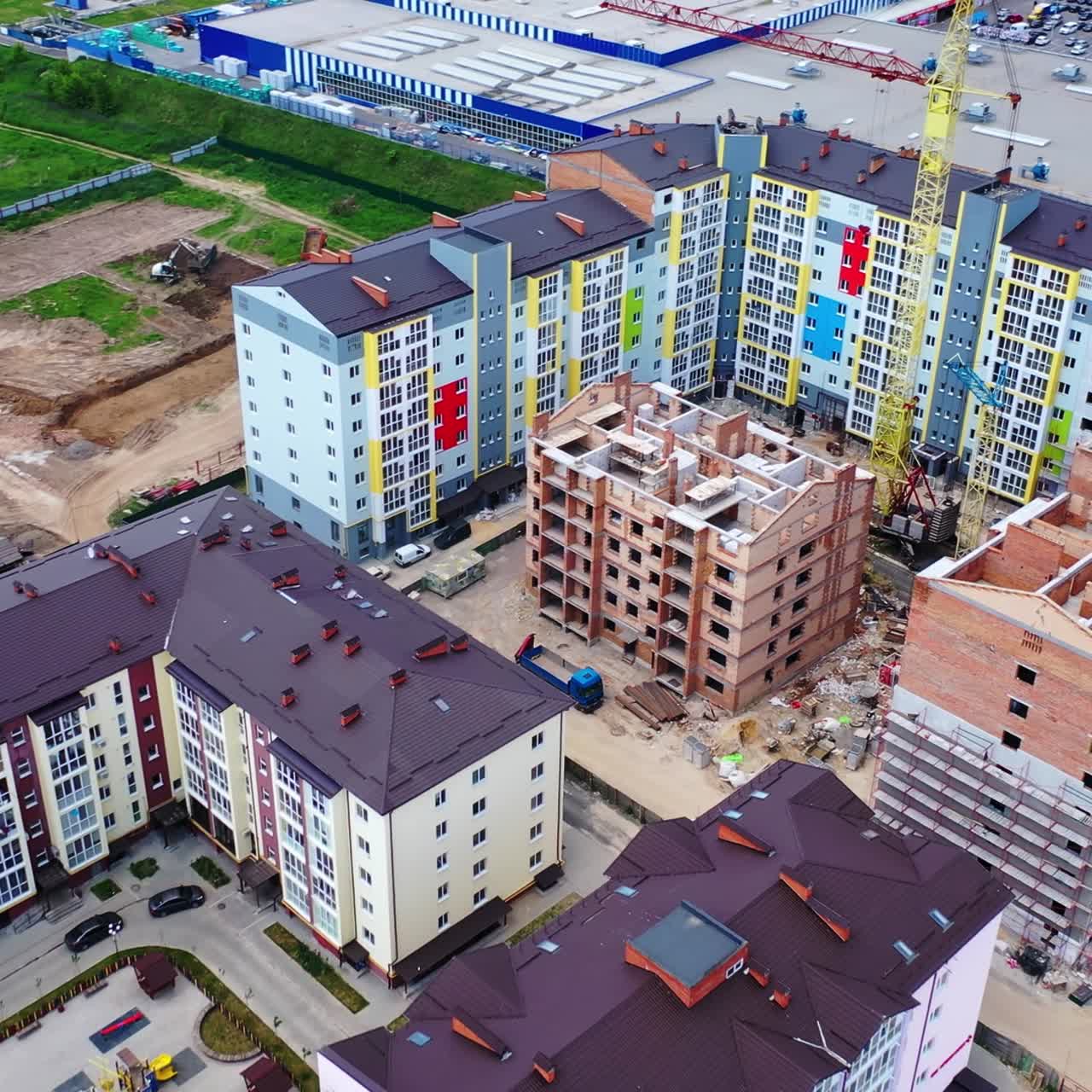 Construction of a new residential complex. Modern multi-storey buildings build in the city. Construction site with high cranes. Aerial view