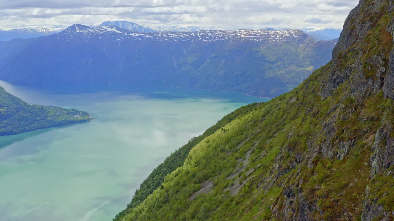 Majestic aerial view of Sogndal, Norway with the Sognefjord, lush mountains, and Sogndal Bridge under clear skies. Breathtaking Nordic landscape in soft natural light