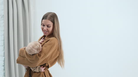 happy smiling long-haired woman waving her baby. loving mother swaying her child to sleep.