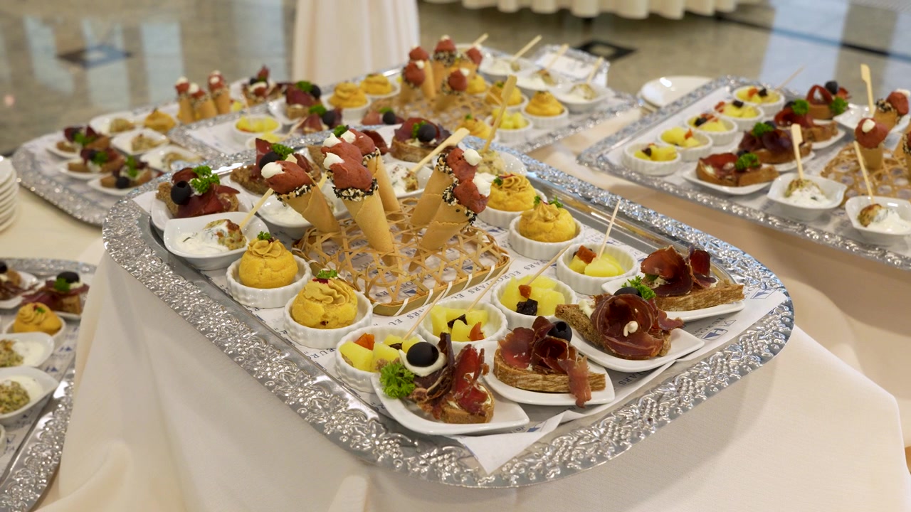Banchetto per eventi, canapè e antipasti gourmet assortiti serviti su vassoi da catering