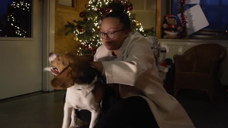 black woman petting her dog during christmas