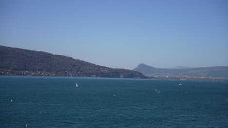 Segelboote-Auf-Dem-See-Von-Annecy-In-Den-Französischen-Alpen-An-Einem-Sonnigen-Tag,-Weites-Schwenken-Rechts