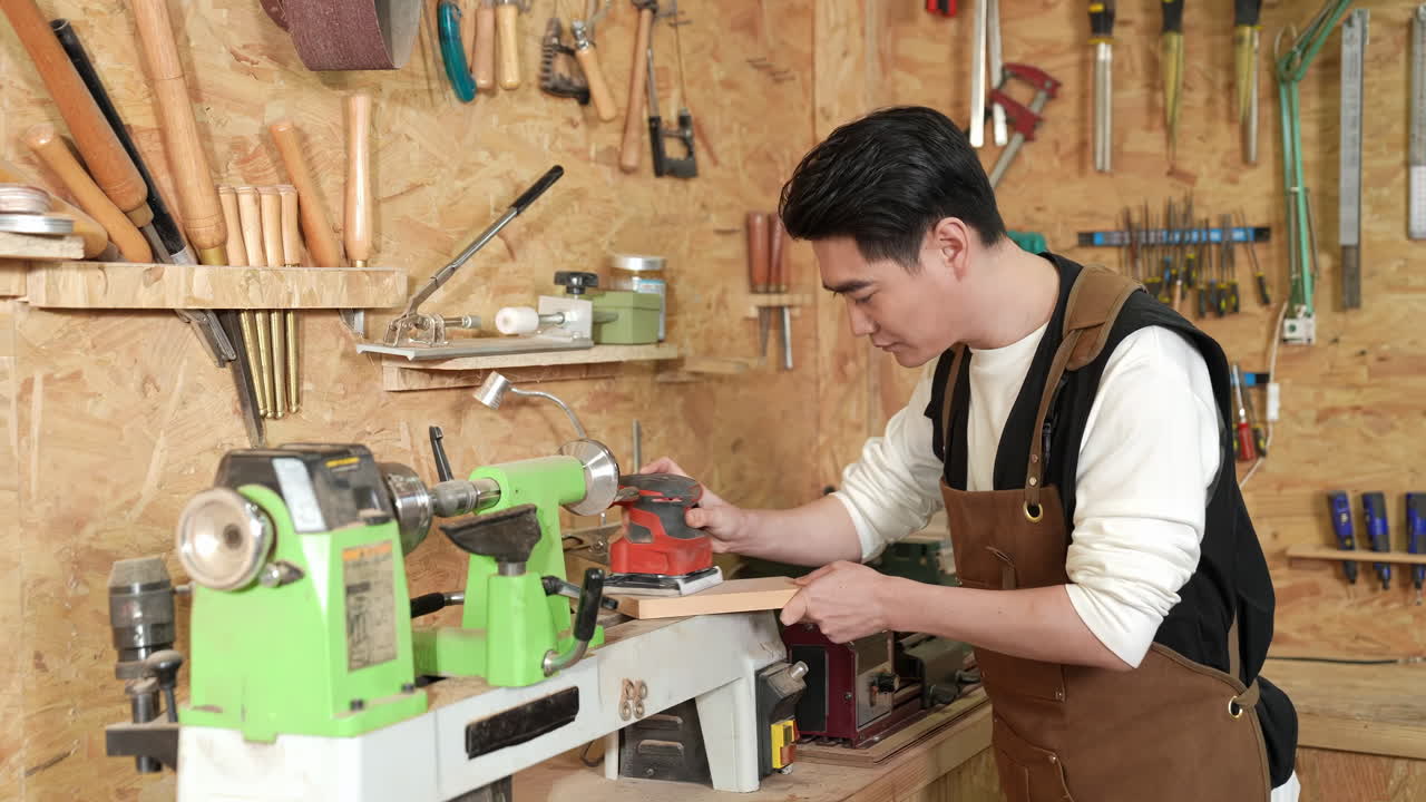 Eco friendly woodworker's shop, skilled carpenters handmade craftsman builder equals polishes wooden board with polishing machine or random orbit sander, sanding wood block, diy master class workshop