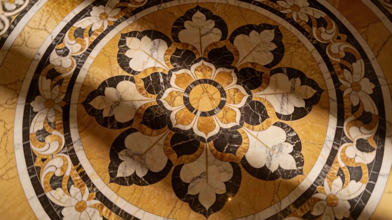 Luci a soffitto che si spostano muovendo un'ombra curva attraverso un medaglione di marmo sul pavimento della hall, mostrando bagliori.