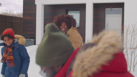 african american family playing snowballs on winter day