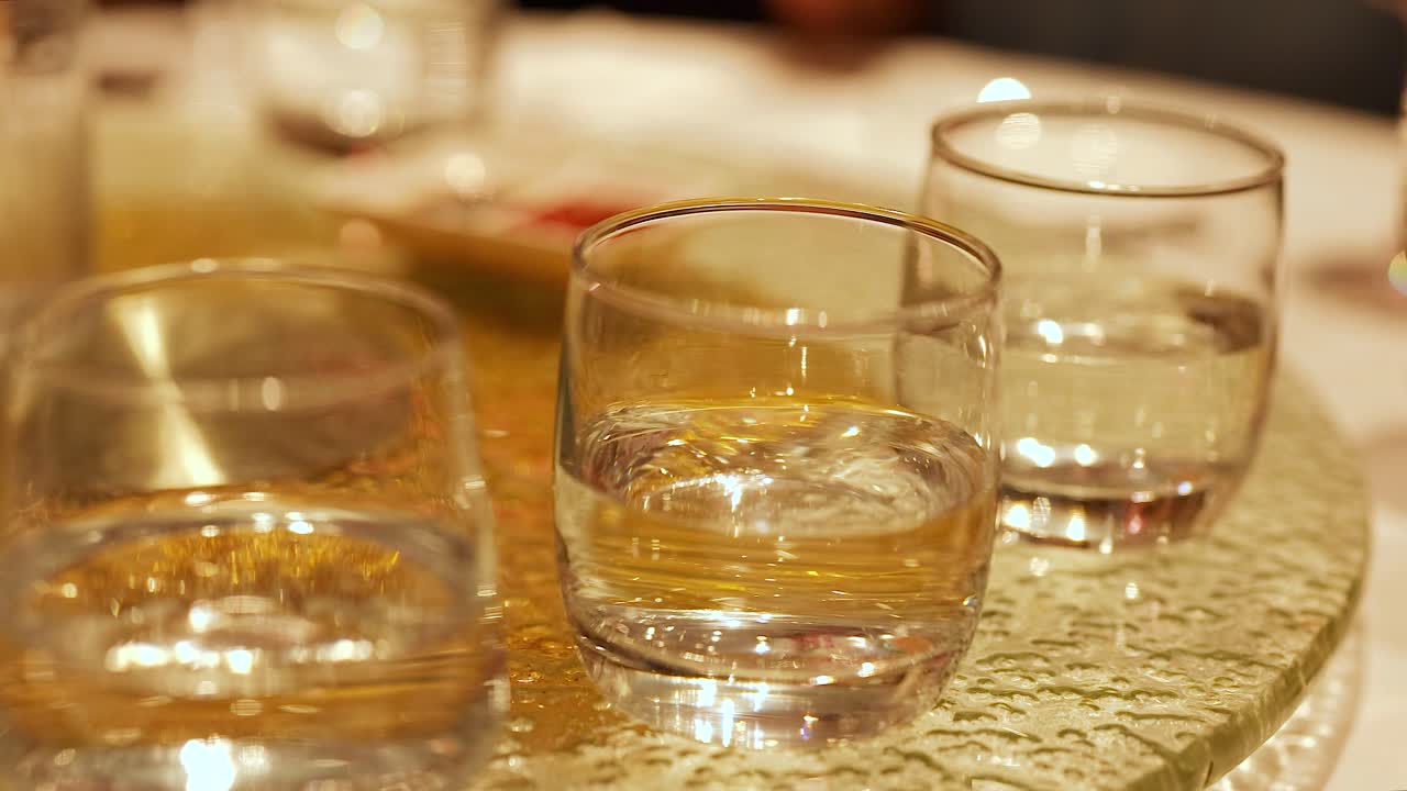 Glasses of water on a rotating table in a warmly lit Chinese restaurant, creating a dynamic visual effect