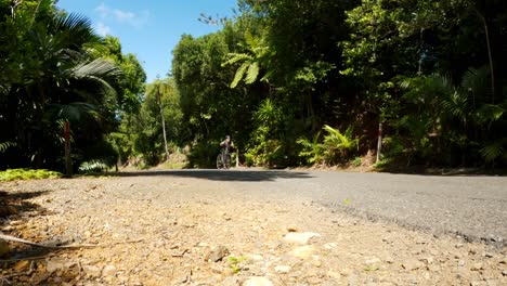 Bajo-El-Cálido-Cielo-De-Verano,-Un-Joven-Cansado-Decide-Empujar-Su-Bicicleta