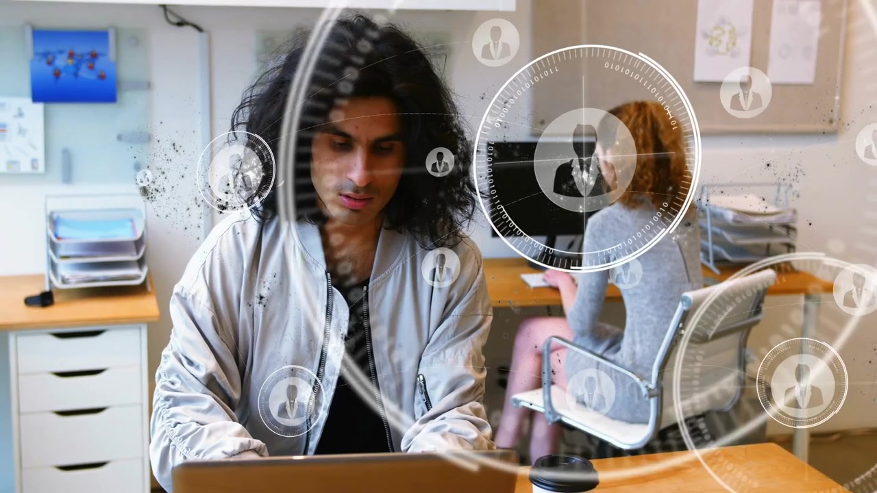 Uomo che digita su un laptop, donna che digita su un computer desktop, HUD che appare vicino a lei con icone che si espandono mostrando una rete tecnologica