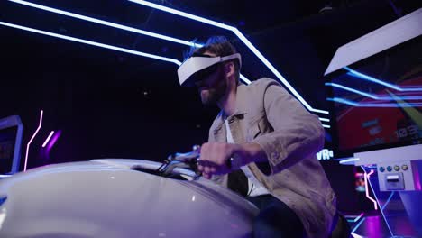 man experiencing vr motorcycle simulator in an arcade