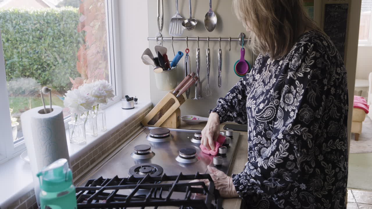 Woman cleaning her kitchen stove