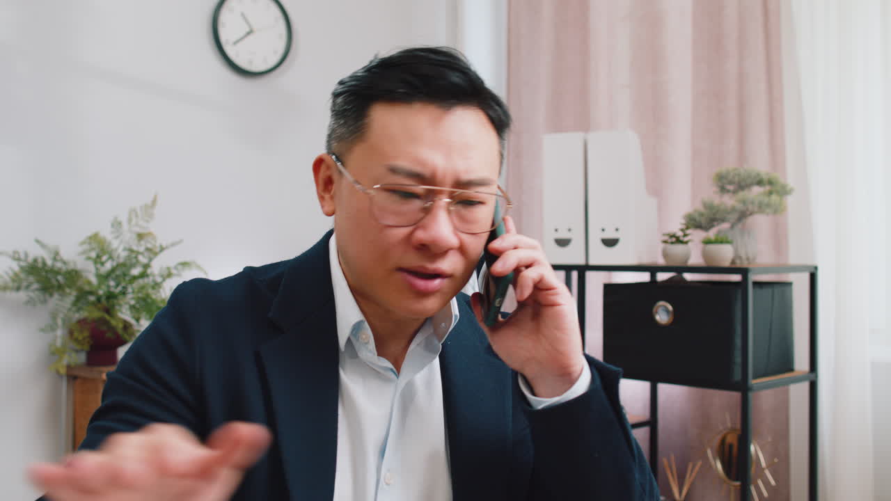 Asian Man on Phone Call Expressing Concern or Frustration