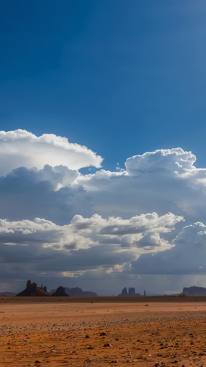 Vertical video: Rimming edges sun urging cumulus building casting shadows over desert plain buttes