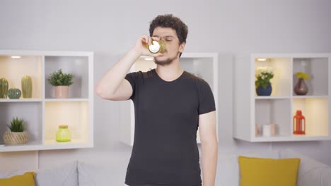 man doing sports exercises at home drinking water.