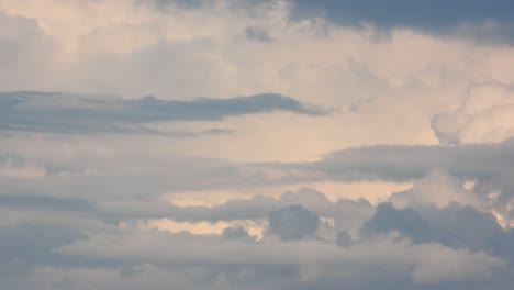 cumulus and stratus clouds cross as currents of wind mix dark stormy clouds, timelapse