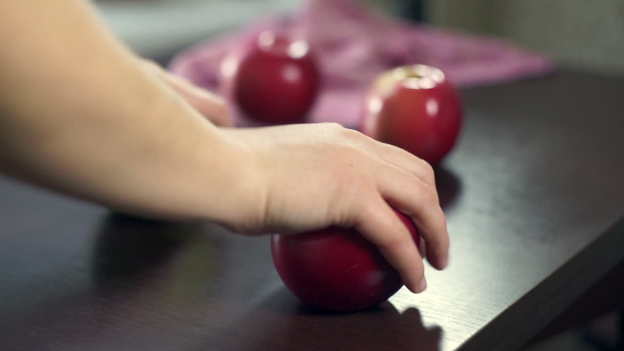 возьмите рукой красные яблоки с деревянного стола. свежие фрукты. вегетарианская еда