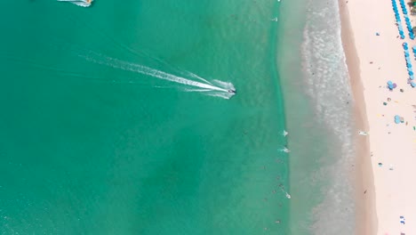 a distant orbit aerial drone shot of the sandy-white kata beach located in phuket island, in the south of thailand