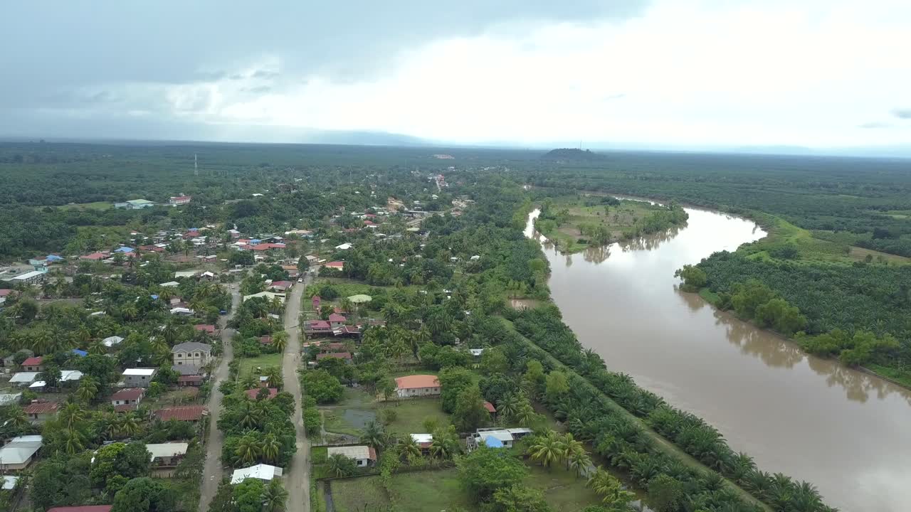 Small town surrounded by a river in a green plantation