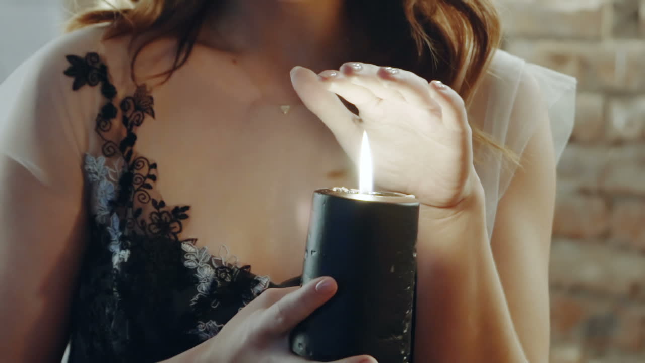 Dark story about witch. Woman in a witches costume guessing with candle