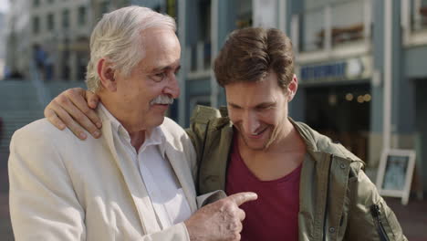 family reunion portrait of elderly father and adult son smiling happy embracing hugging enjoying vacation together