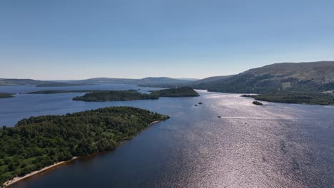 sunny day on loch lomond flying above islands with boats out cruising