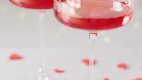 video of two red drinks in cocktail glasses with heart clips, selective focus with copy space