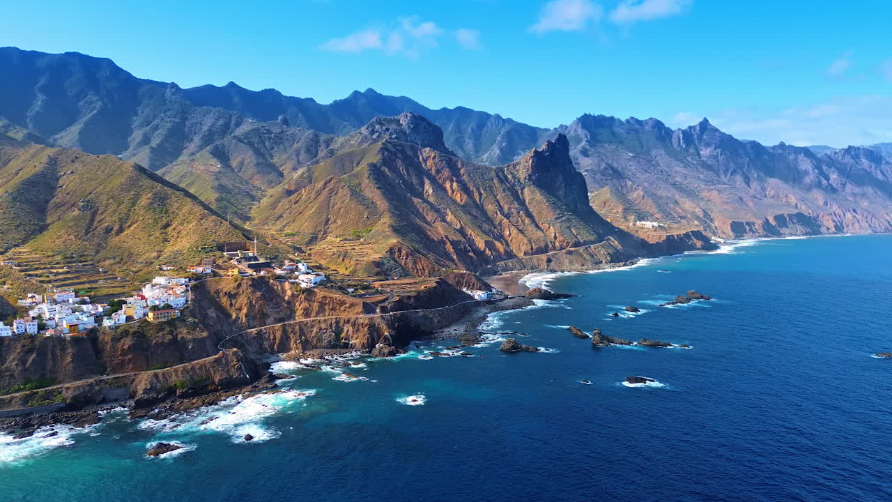 Grupo de villas situadas en la costa rocosa del océano Atlántico. Vista de las inaccesibles montañas desnudas de Tenerife, Islas Canarias, España. Perspectiva aérea