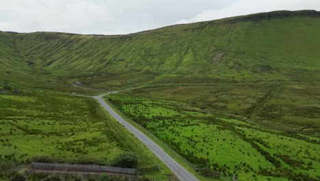 drone shot of a car in the distance driving along the road by glenniff horseshoe