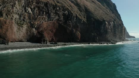 Steep-rocky-cliffs-of-Madeira-with-water-from-Atlantic-Ocean,-aerial