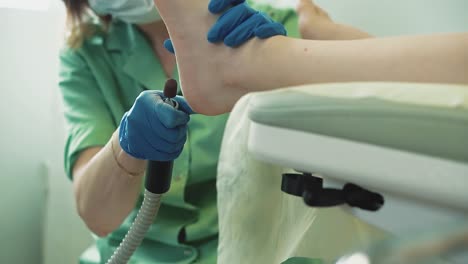 una chica bonita se sienta en una silla en un salón de belleza se le da una pedicura 1