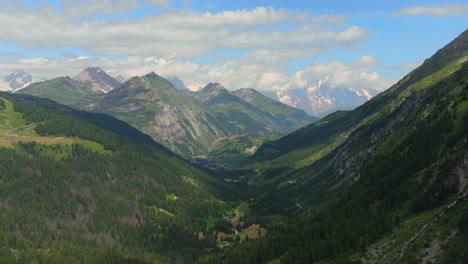 Impresionante-Vista-De-Exuberantes-Valles-Verdes-Y-Picos-Nevados-En-Los-Alpes-Italianos-Bajo-Un-Cielo-Brillante