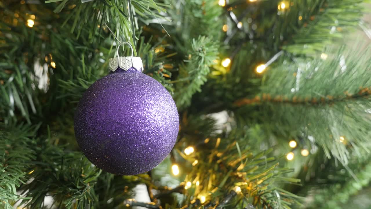 bola de navidad púrpura con pañuelos colgados en la rama del árbol video 4k