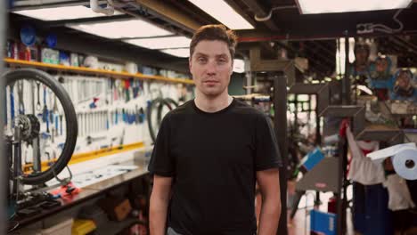 cheerful man in bicycle repair workshop