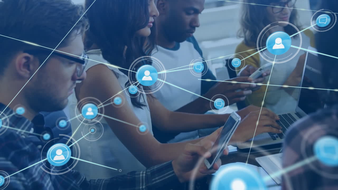 Animation of connected icons over diverse coworkers using cellphone and laptop in office