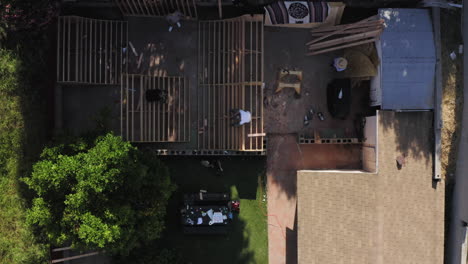Top-down-drone-view-of-people-in-back-yard-building-skate-ramp