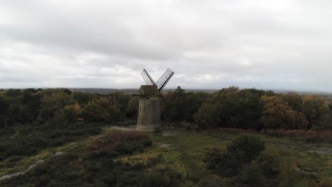 Traditionelle-Holzmühle-Windmühle-Aus-Holz-Stein-Erhalten-Im-Herbst-Wald-Luftbild-Landschaft-Rechts-Langsam-Dolly