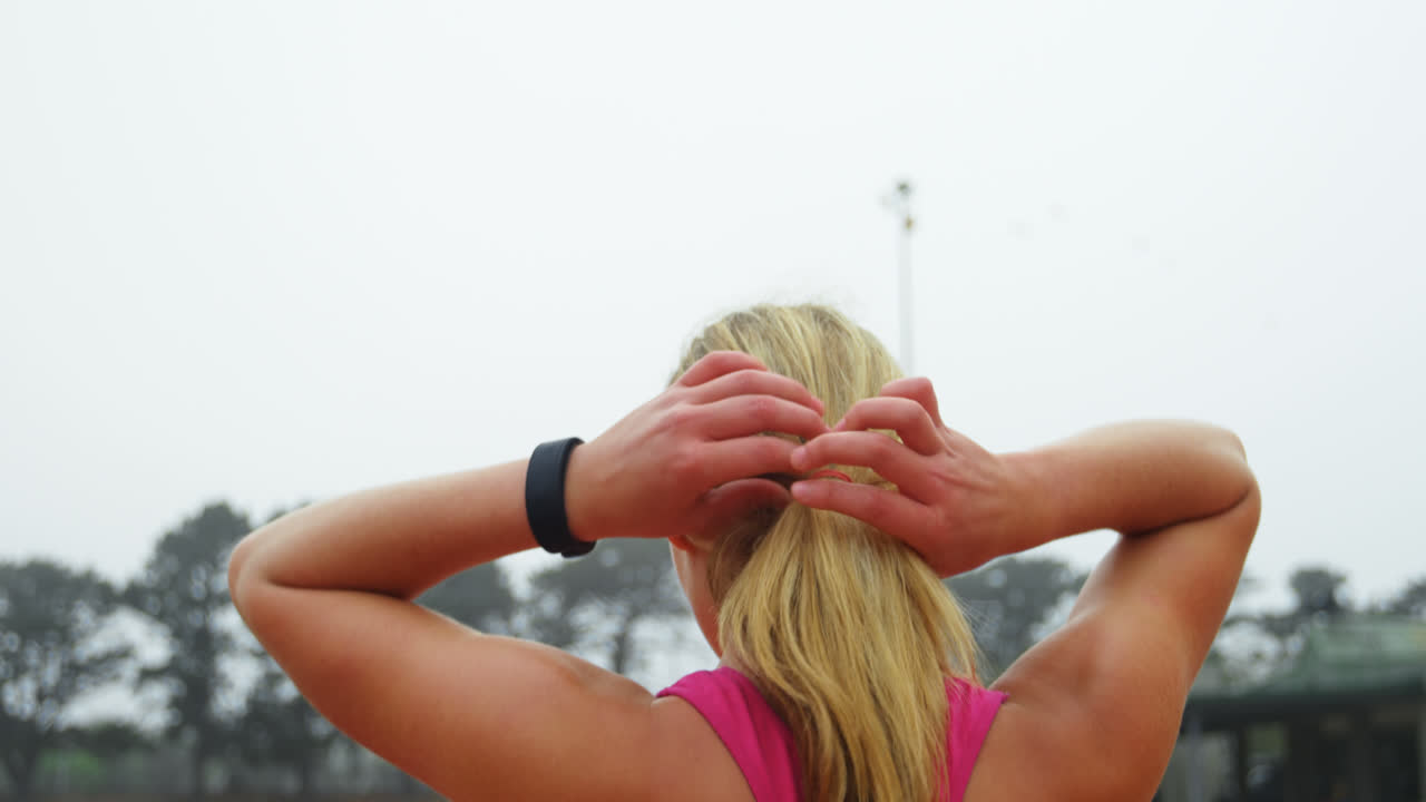 vista trasera de una atleta caucásica de pie en una pista de carreras 4k