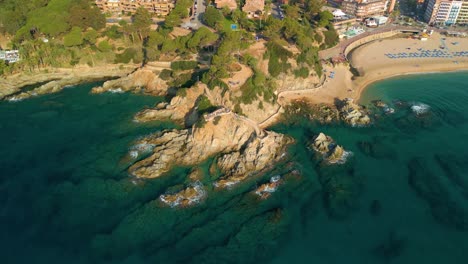 Kreisförmige-Luftaufnahme-Von-Cala-Banys-Am-Strand-Von-Lloret-De-Mar,-Costa-Brava