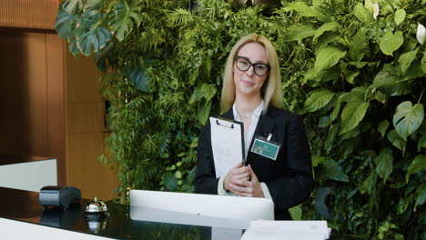 la recepcionista rubia detrás del mostrador