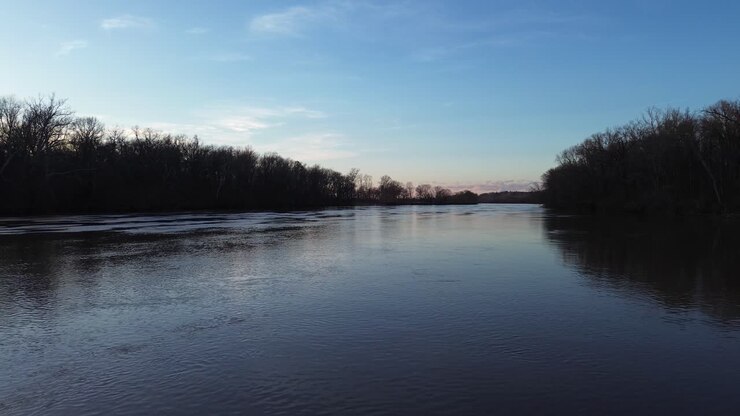 Drone shot over still James river water surface in cold winter morning