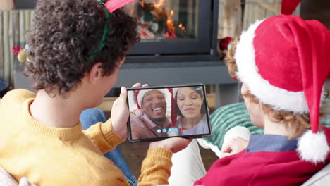 pareja feliz diversa y amigos masculinos teniendo navidad llamada de video de tableta, cámara lenta