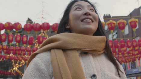 retrato de una joven asiática sonriente visitando el barrio chino de londres, reino unido