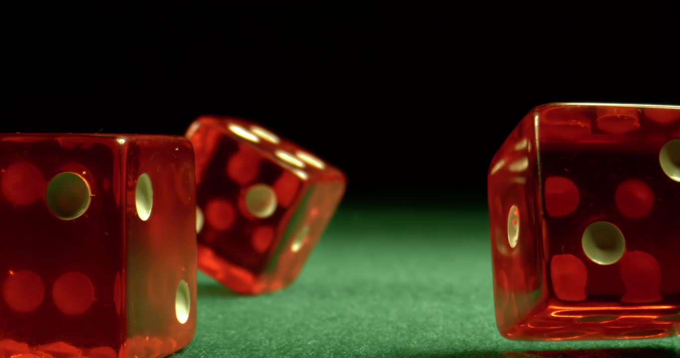 Des dés volent et culbutent vers la caméra en ralenti extrême, atterrissant sur une table de casino verte avec