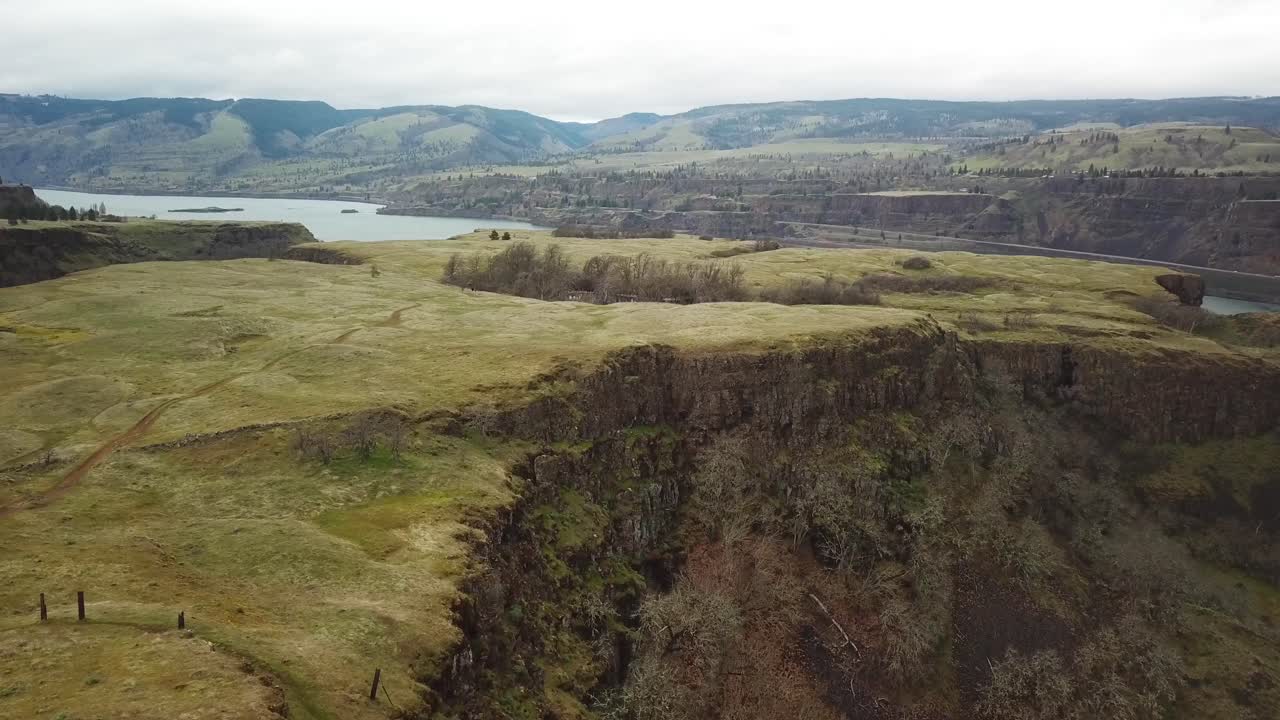 Flying Above Dramatic Cliffs And Rolling Terrain With Scenic River Views