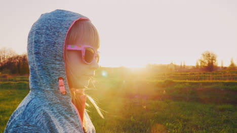 girl 6 years old in a hooded tracksuit at sunset