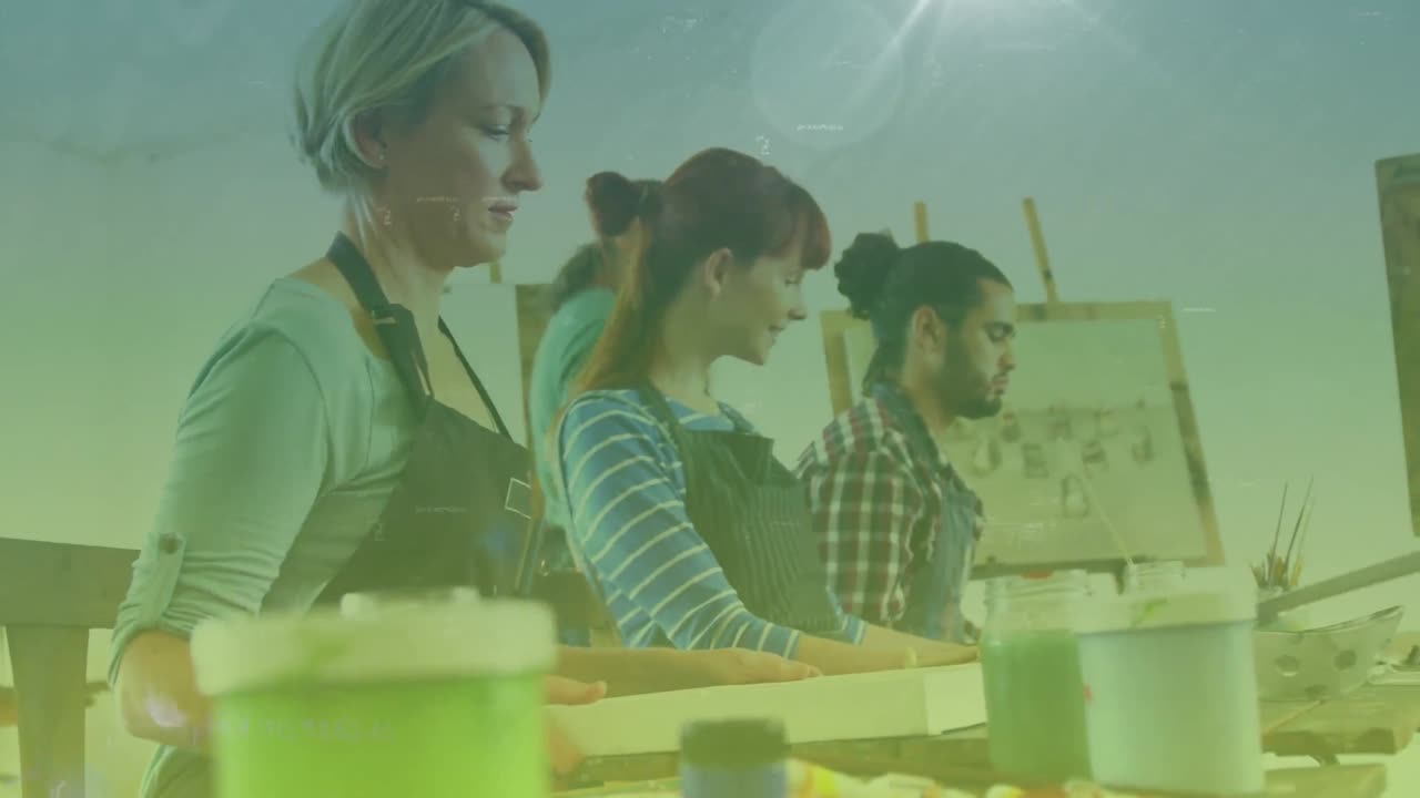puntos de luz contra un grupo de personas diversas pintando en el estudio