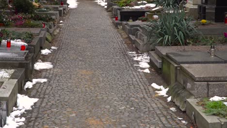 tilt up over european cemetery with graves and offerings