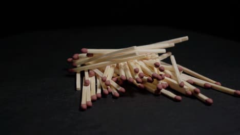 pile of matches rotating on black background, closeup