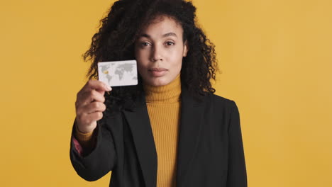 una mujer afroamericana segura de sí misma sobre un fondo naranja.